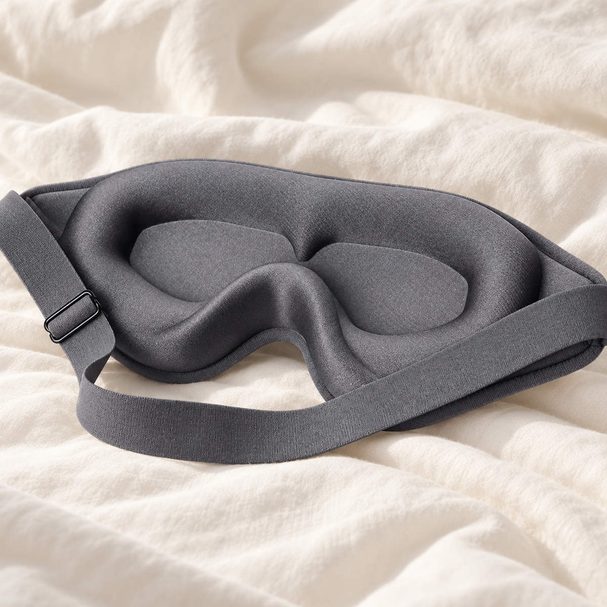 Gray 3D sleep mask showing contoured eye cups and adjustable strap